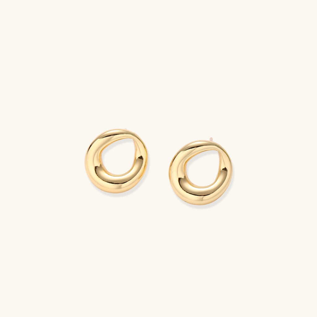 Pair of polished 18K gold-plated stainless steel teardrop earrings with hollow centers on cream background