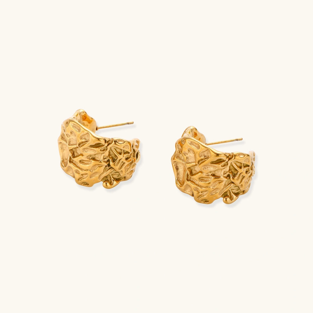 Chunky gold-plated hoop earrings with organic crumpled texture on cream background, 21.5mm sculptural design