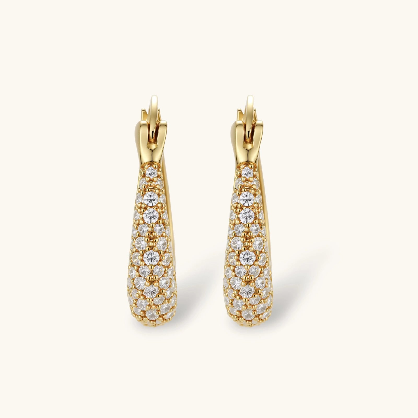 Gold-plated hoop earrings fully covered in sparkling zircon crystals with hinged closure on neutral background