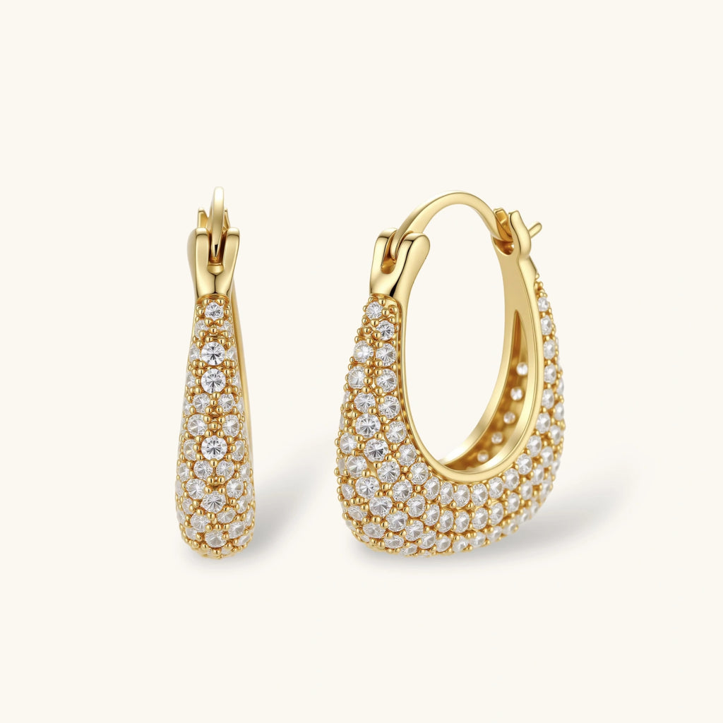 Gold-plated hoop earrings fully covered in sparkling zircon crystals with hinged closure on neutral background