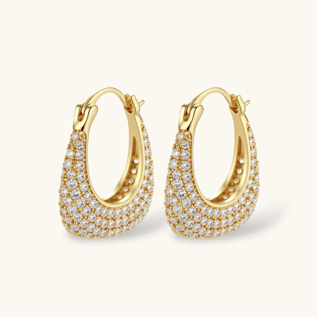 Gold-plated hoop earrings fully covered in sparkling zircon crystals with hinged closure on neutral background