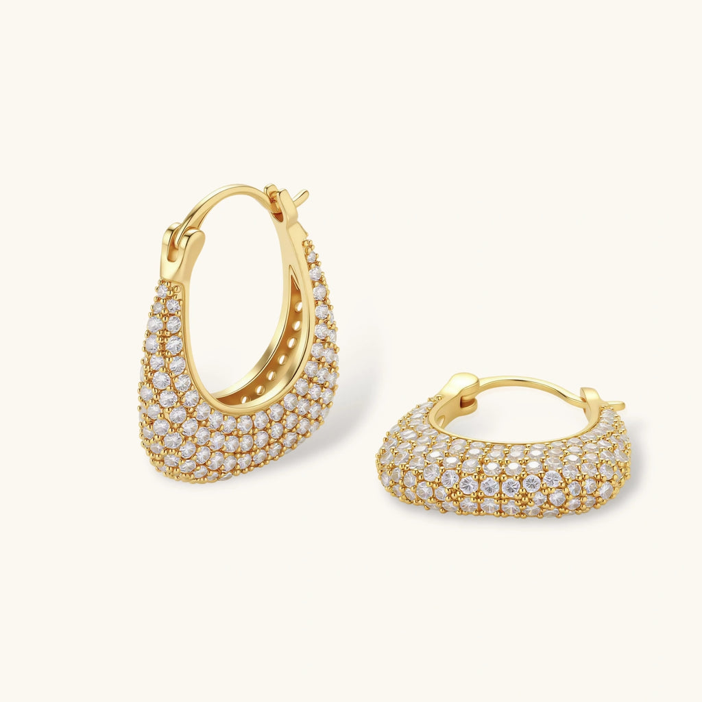 Gold-plated hoop earrings fully covered in sparkling zircon crystals with hinged closure on neutral background