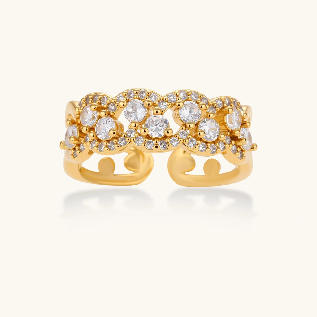 Adjustable gold-plated ring with multiple crystal clusters in intricate chain design on cream background.
