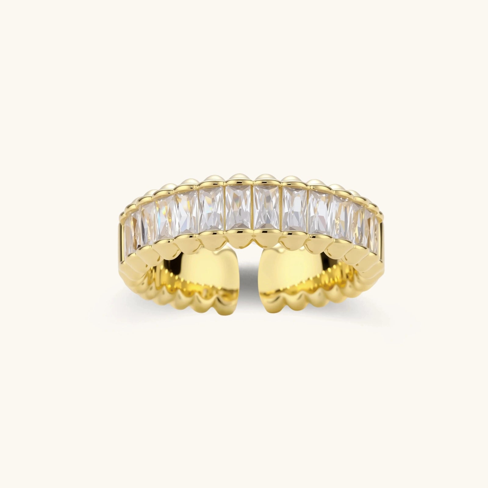 Adjustable gold-plated ring with rectangular cubic zirconia stones in eternity band style on neutral background.